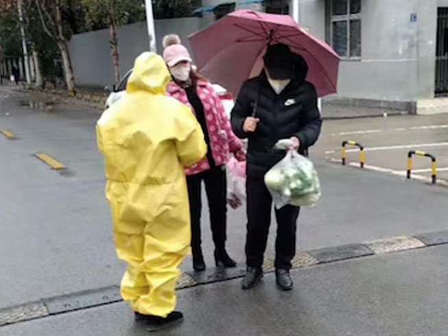 Courageous Christians (pictured in yellow suit) risking their own health to hand out protective masks and gloves, along with comforting words, to panicked residents in Wuhan