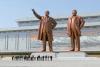 Citizens of North Korea bow before giant statues of former leaders