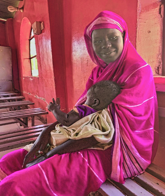 In the prison chapel. This Christian woman, originally from the Nuba Mountains, was jailed in Khartoum under sharia in 2019 and her baby was born in prison. They are now released and reunited with family