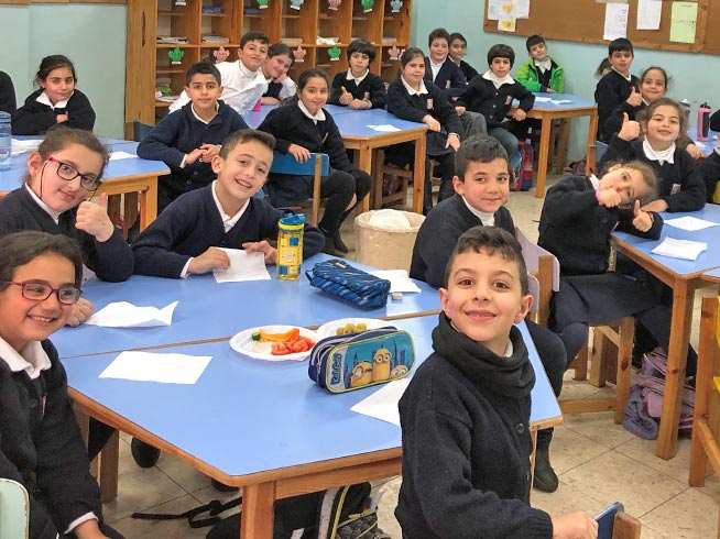 Grade 2 children enjoy a healthy snack at break time. Will you help children from some of the poorest Christian families in the Holy Land get an education in a loving Christian environment?